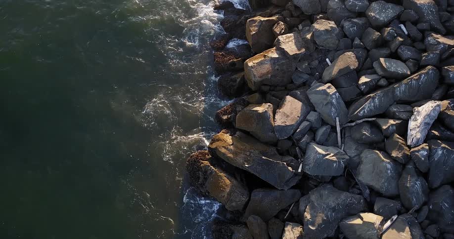 The waves are crashing against the rocks on the shore