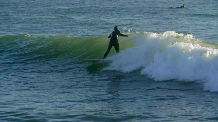 A surfer is surfing a wave