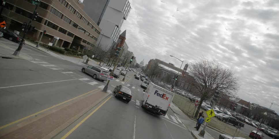 Traffic flows through a city intersection on a cloudy day