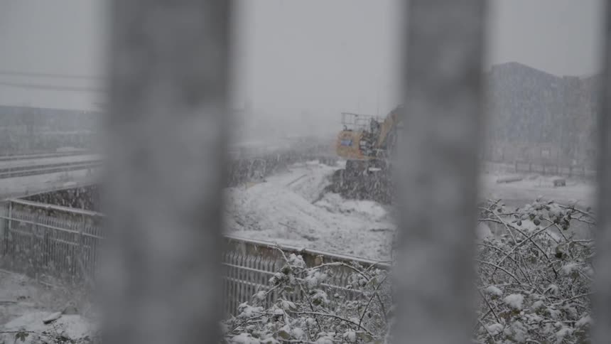Snow is falling on a farm