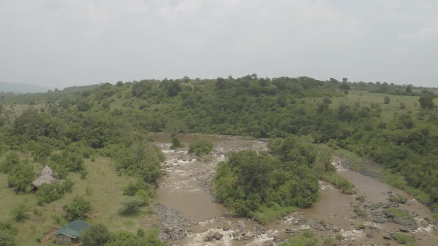 A small river surrounded by a forest is being flown over