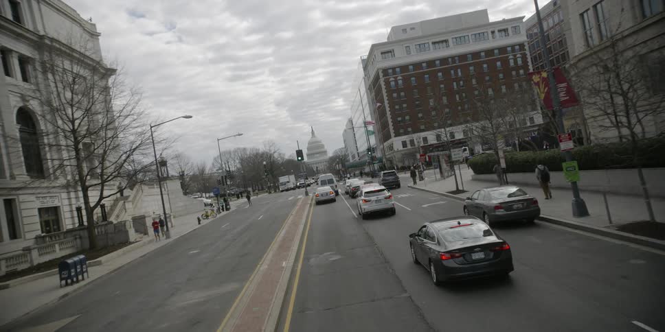 Cars drive on a city street