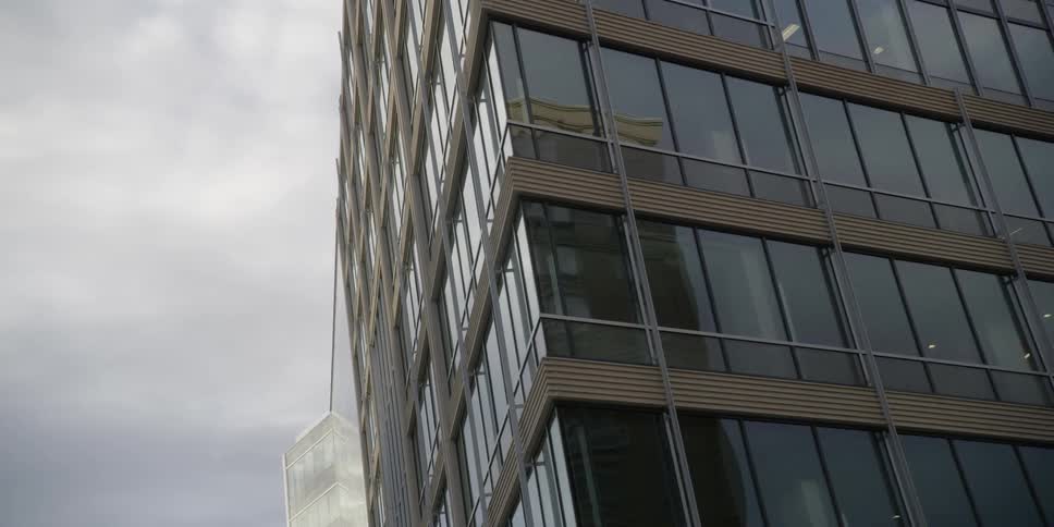 A glass building is being filmed from the street