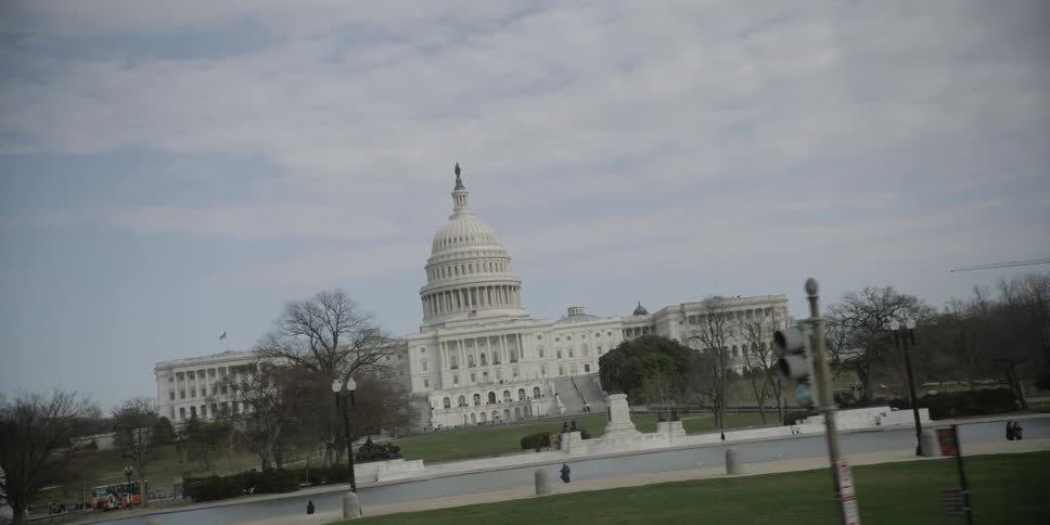 Large white building sits under a cloudy sky