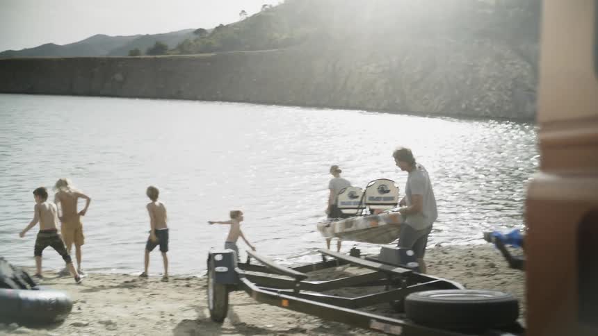 A family are at a lake putting boats in the water