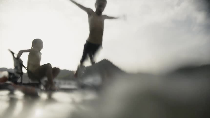 A child dives from a boat into the water