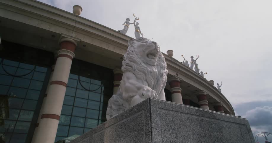 A lion sculpture standing outside a large building