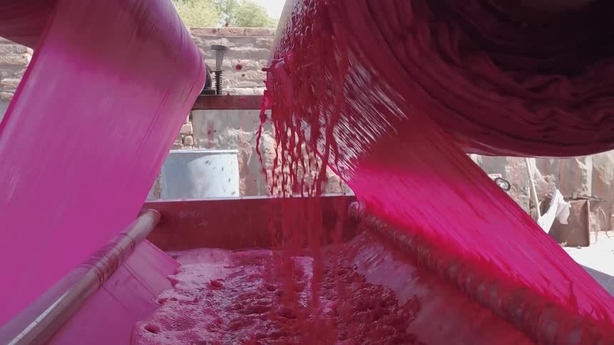 Red liquid is pulled through rotating drums