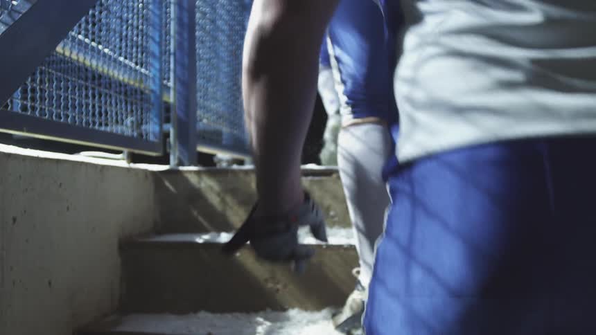 Players in uniform walking up stone steps
