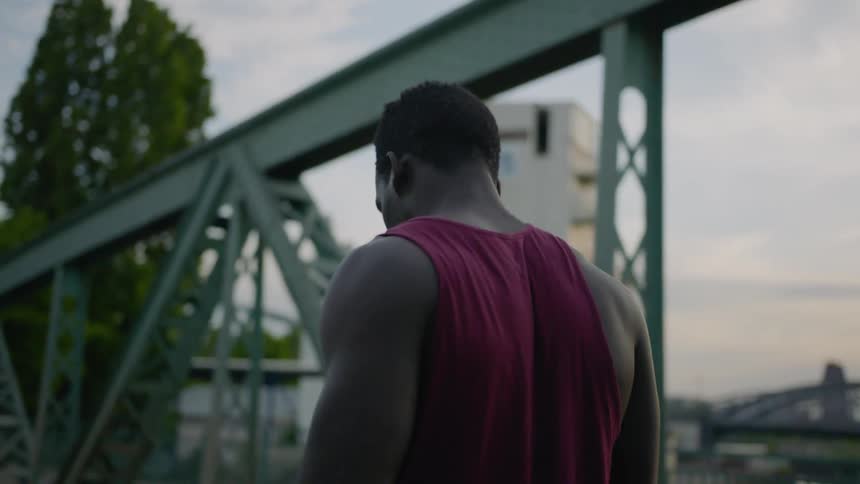 A man is walking over a bridge during the day