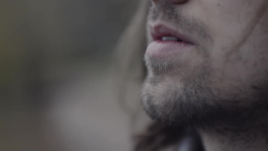 Whiskers on a man's face and then the man looks upward