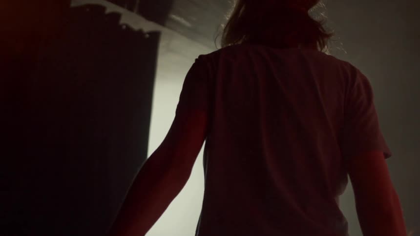 Woman walking into a room with a lighted area
