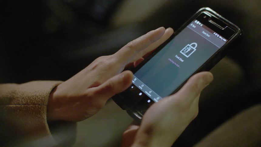 A woman is pressing the screen on her phone