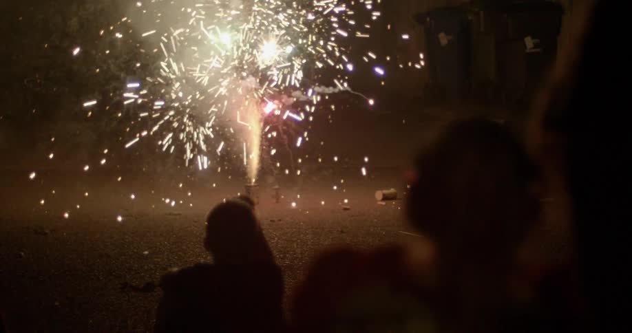 Children watch fireworks explode in the driveway