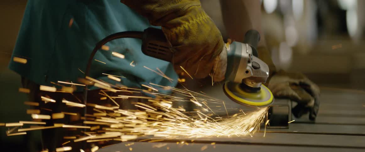 A person is working in a shop grinding metal