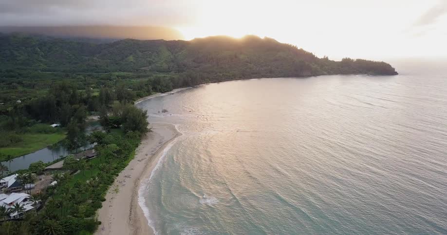 Ocean waves flow towards a beach at sunset