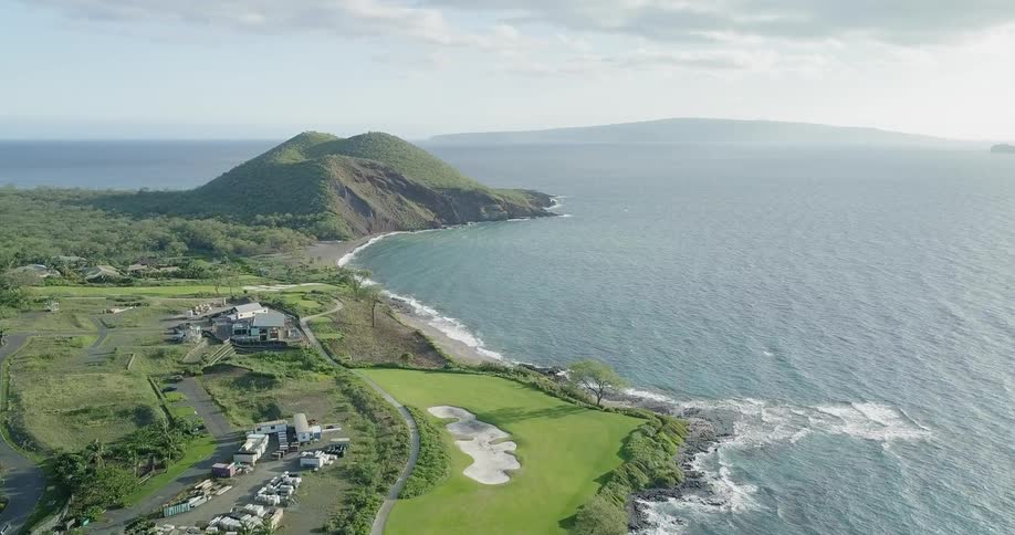 The ocean meets the shore near an island golf course