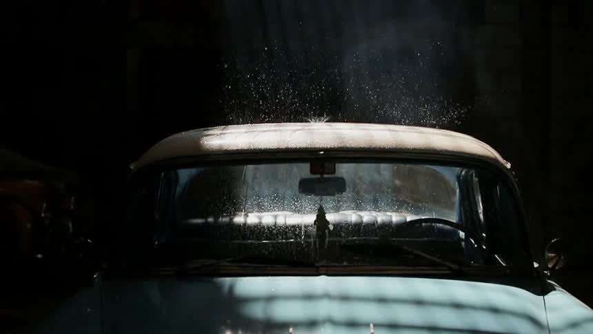 Water drops are falling on a parked late model american car