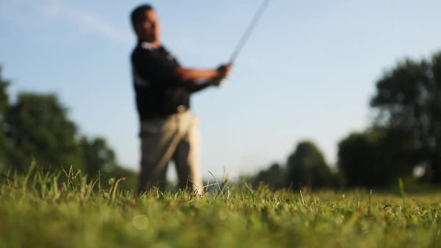 A man drives the golf ball on a sunny day