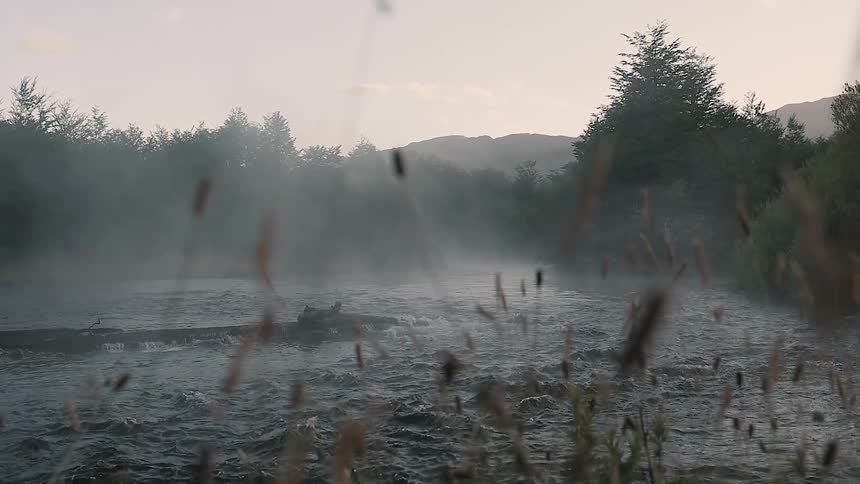 Water flows on a river at sunset