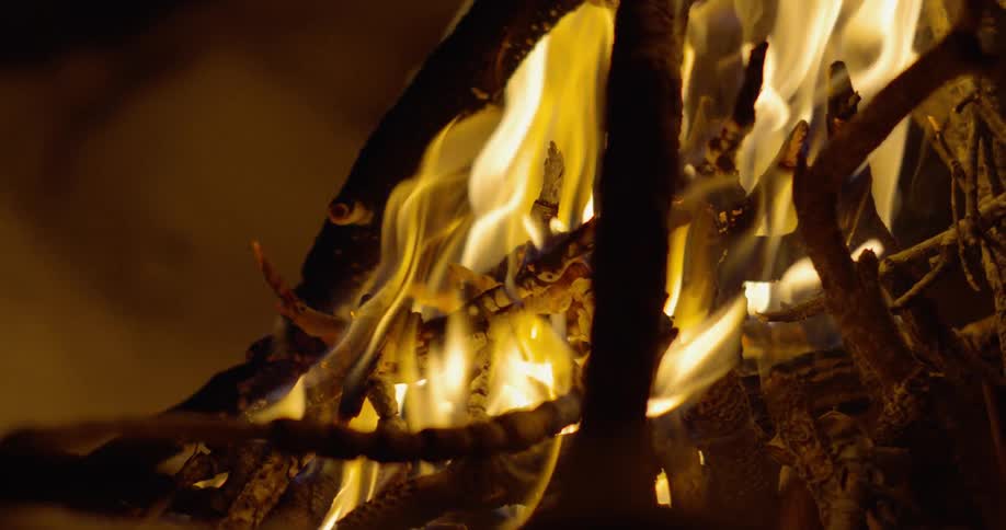 A fire burns outside at night