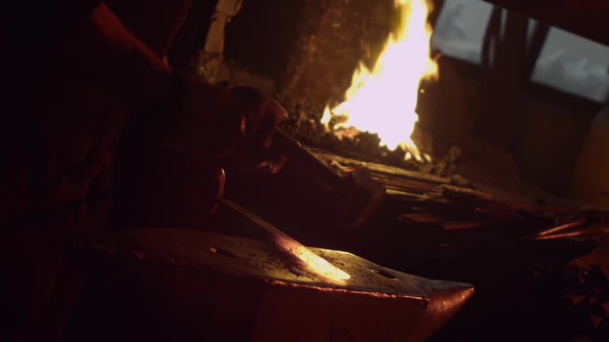 A blacksmith hammering metal on an anvil
