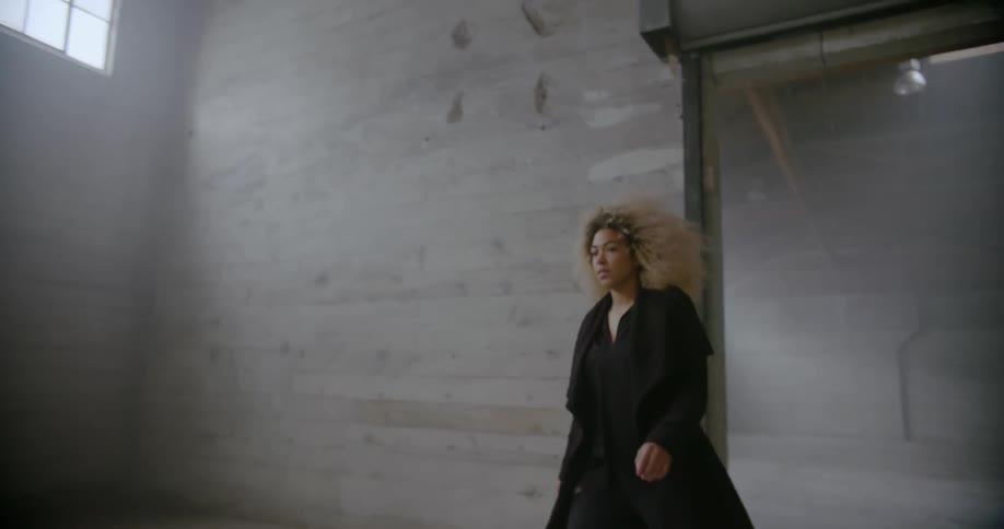 Woman walks across empty warehouse floor