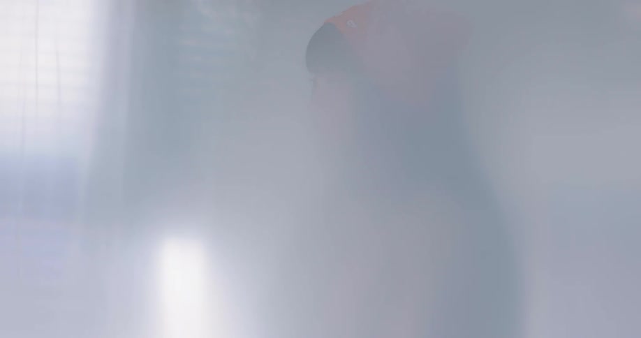 Woman stands swaying in front of a window