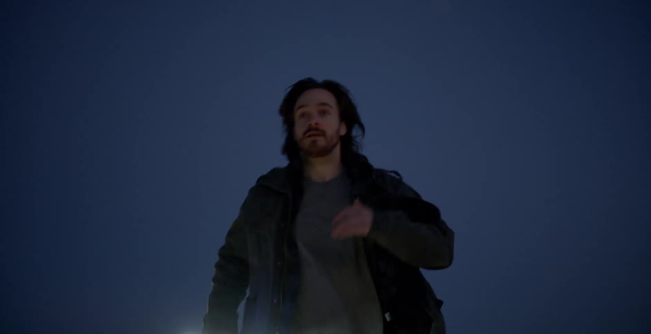 Man runs outside at night with a glowing light stick