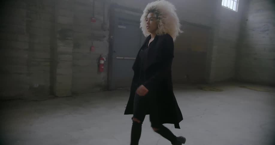 Woman walks across empty warehouse floor
