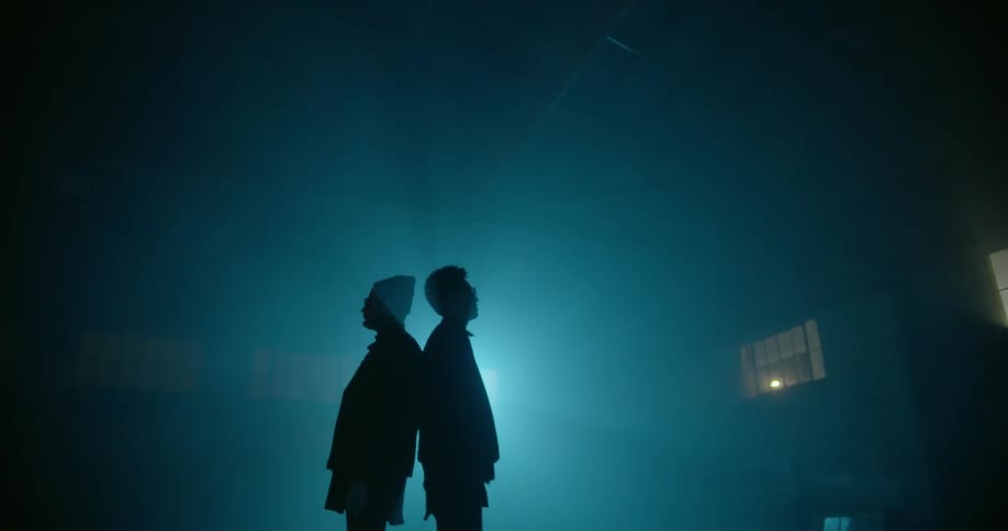 Two men stand back to back