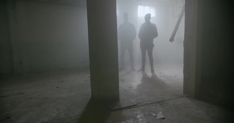 Two men stand in an empty building