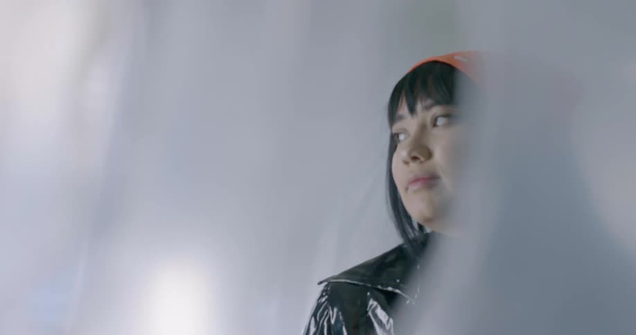 A woman is dancing and swaying indoors during the day