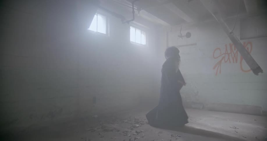 A woman dances in an abandoned building
