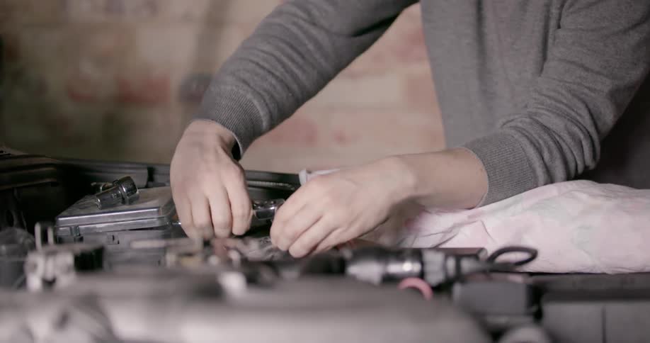 A man is working on the engine of a car