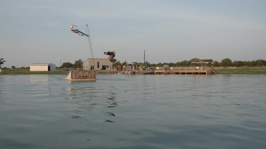 A person does tricks while water skiing