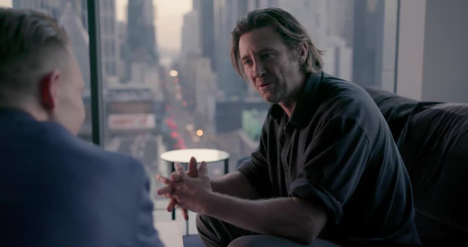 Two man shaking hands while sitting on couches