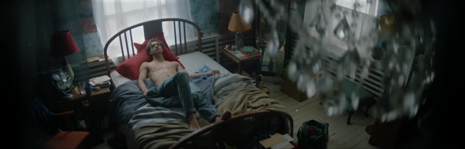 Man Laying In Bed In Room Staring at Ceiling