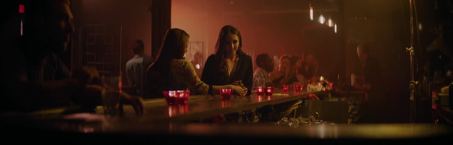 Two woman talking at a bar in a club