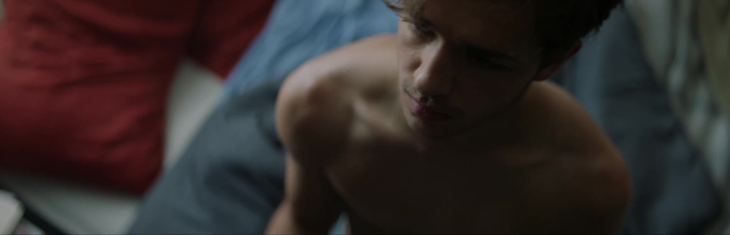 A man looks at his hurt hand in bed