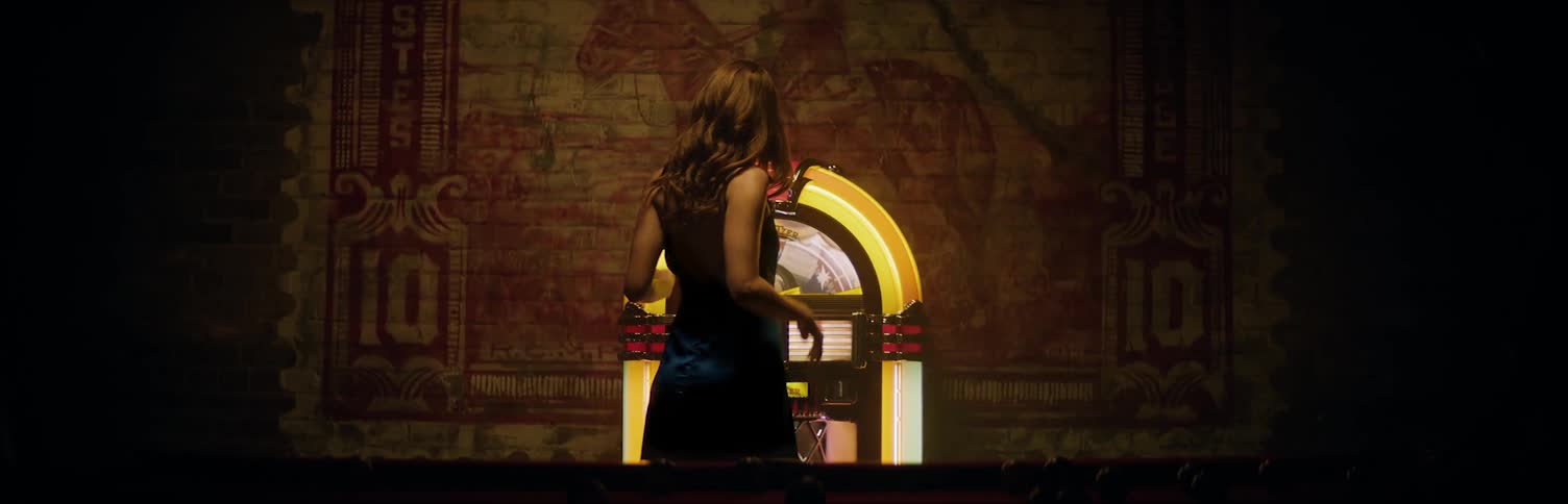 Woman dancing in front of jukebox at club