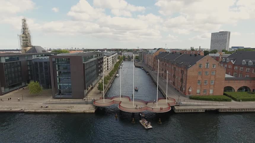 Boat going under bridge in the middle of the city