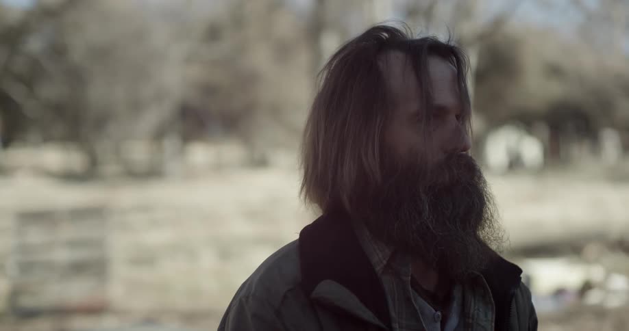 A bearded man stands still