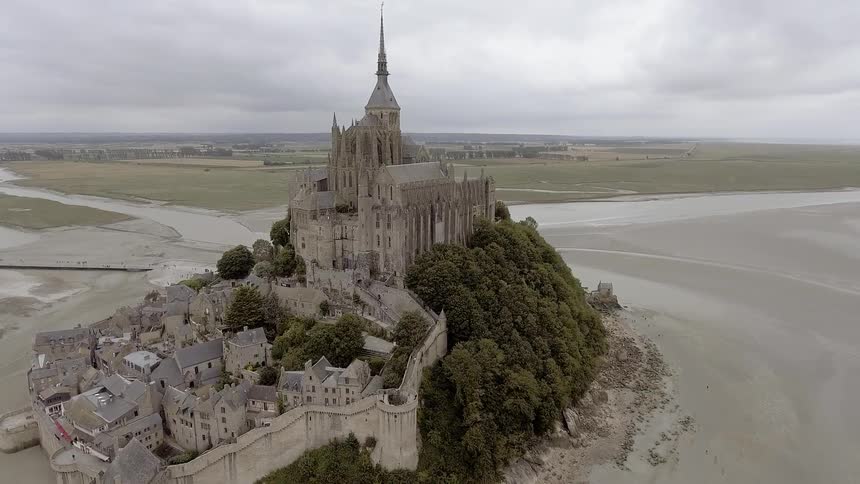 An old castle sits on top of a small rocky hill