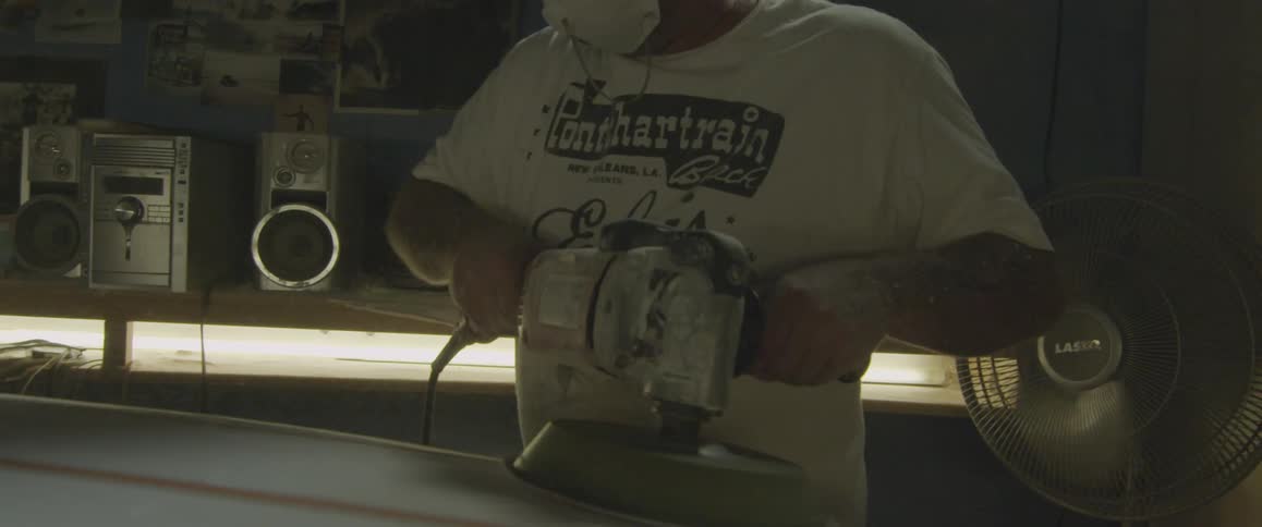 Man using a sanding machine on some boards