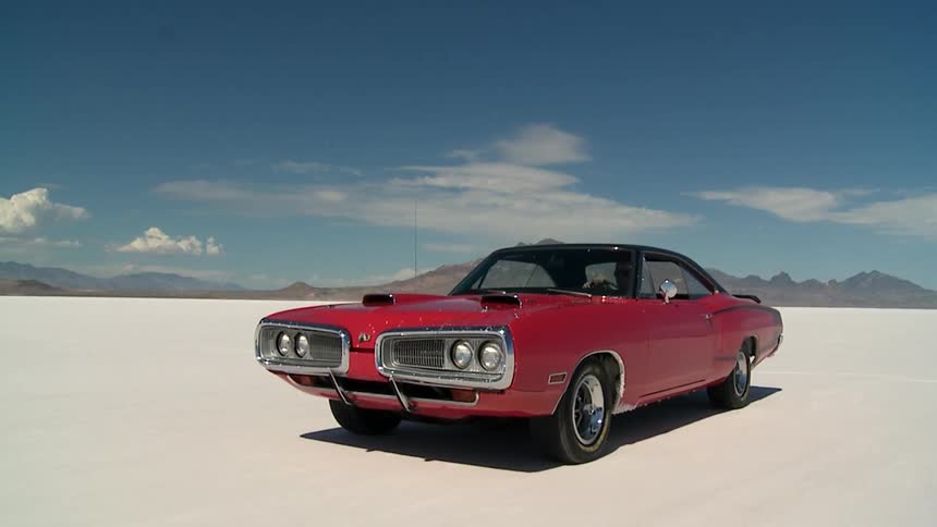 A red car is speeding in the desert