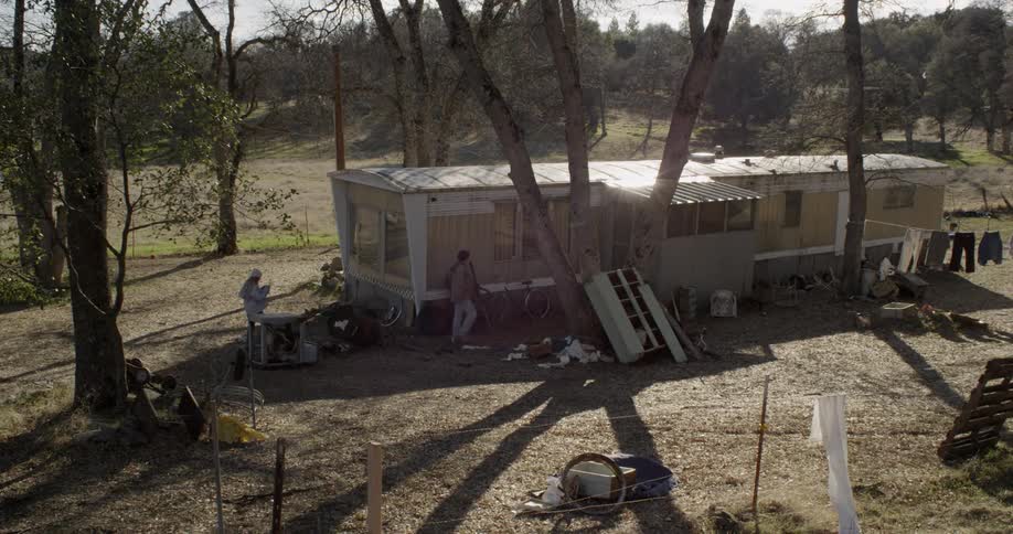 A man and woman roam around a trailer