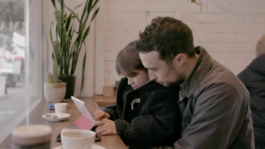 A man with a child on his lap in a cafe