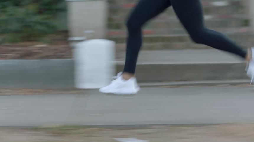 A person runs down a sidewalk