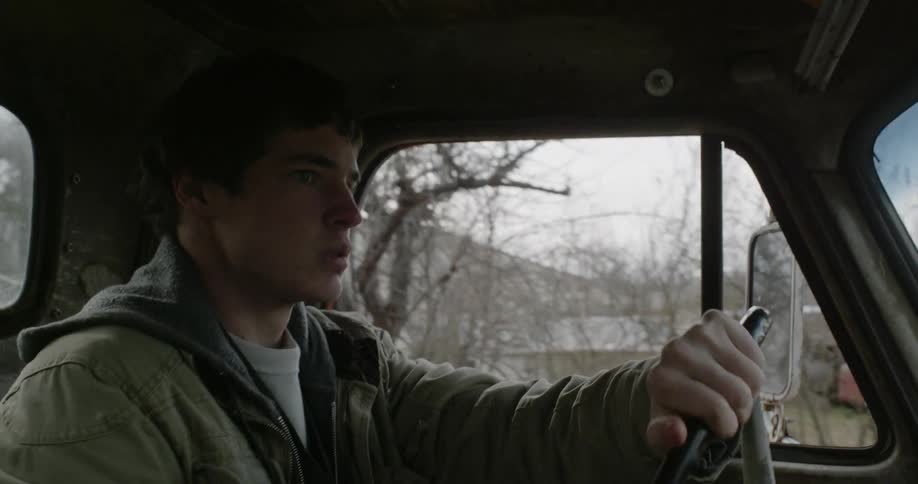 A young man drives a pickup truck